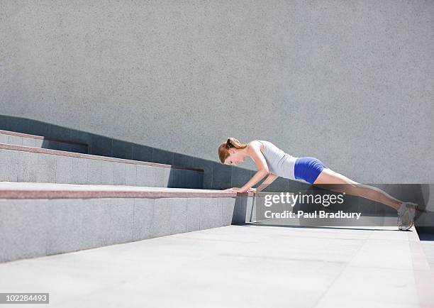 mujer haciendo flexiones en urban escaleras - flexiones fotografías e imágenes de stock