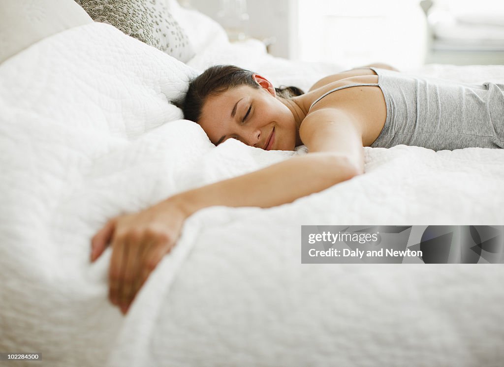 Happy woman laying on bed