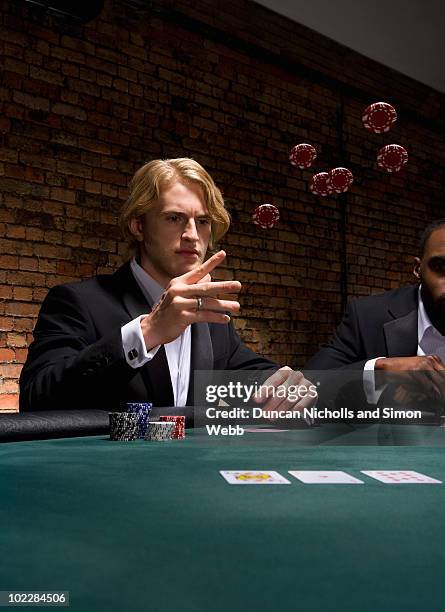 man throwing poker chips in casino - casino elegance stock pictures, royalty-free photos & images