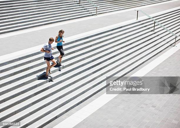 corredor corriendo por las escaleras. - two woman running fotografías e imágenes de stock