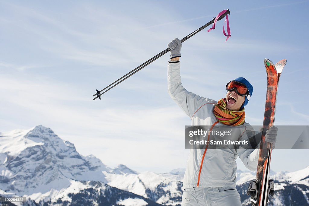 Cheering man holding skis and poles