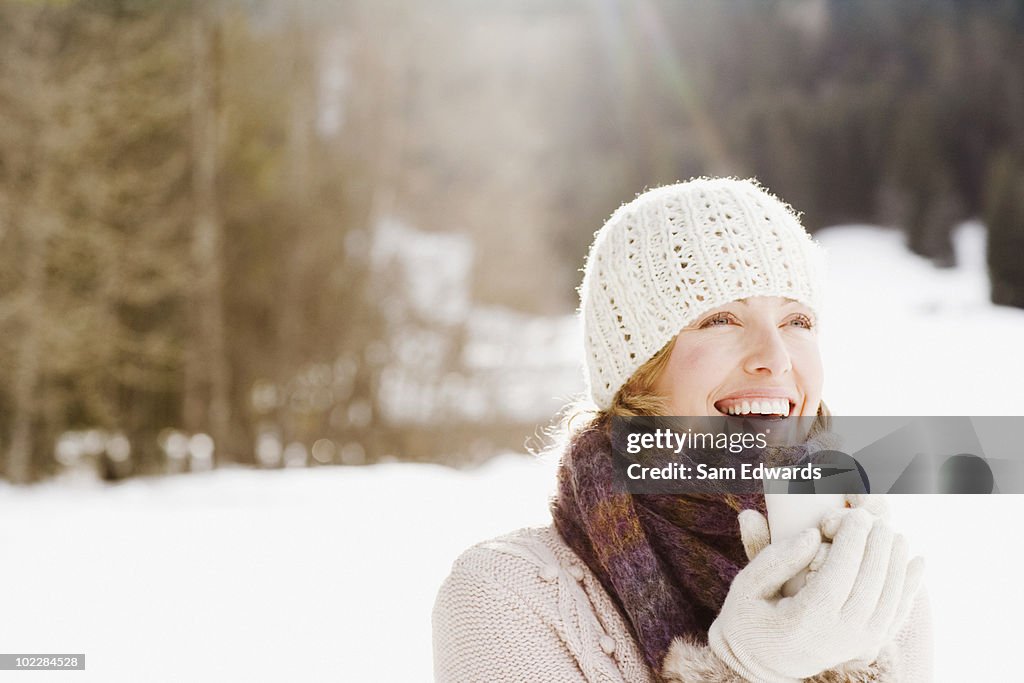 Frau trinkt Kaffee im Schnee