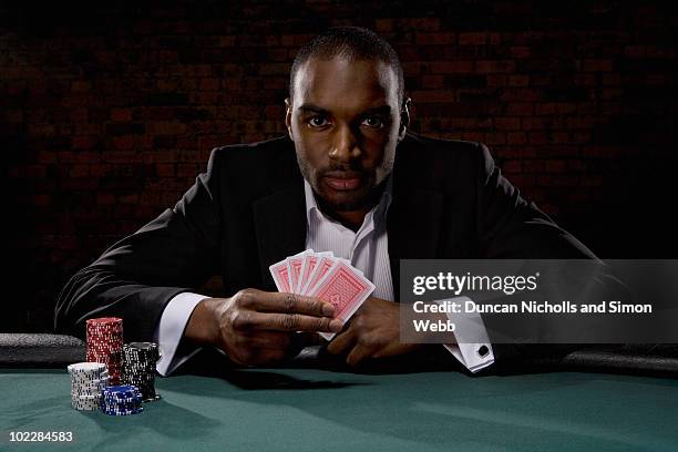 man playing poker in casino - portrait holding card foto e immagini stock