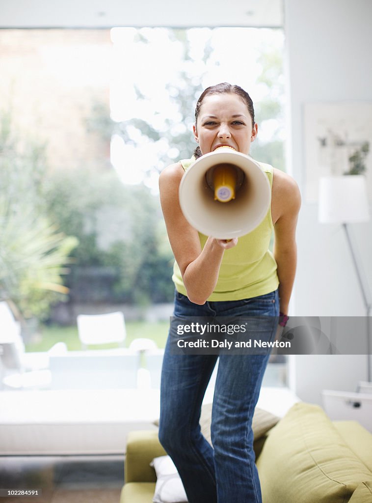 Woman shouting into bullhorn in living room