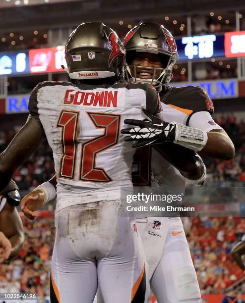 Chris Godwin and Jameis Winston of the Tampa Bay Buccaneers celebrate a touchdown during a preseason game against the Detroit Lions at Raymond James...