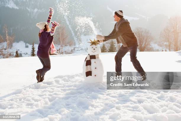 paar machen schneemann - snowman stock-fotos und bilder