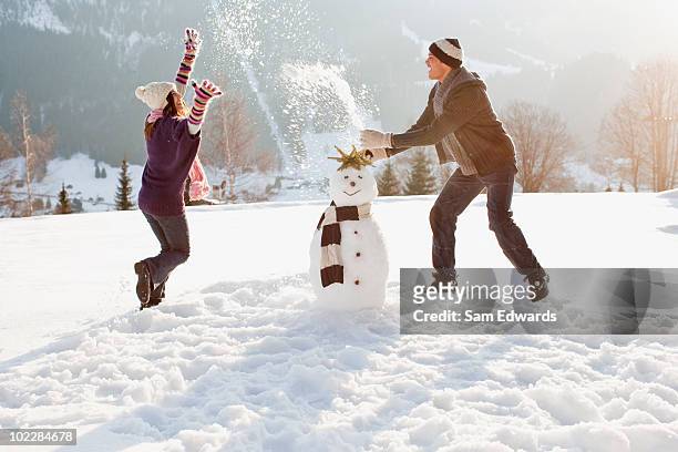 coppia rendendo pupazzo di neve - pupazzo di neve foto e immagini stock