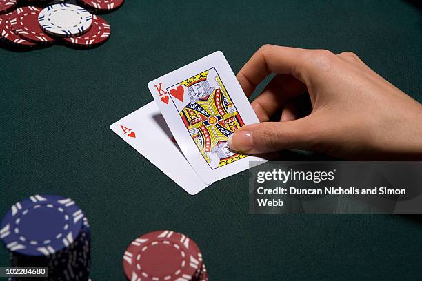 woman playing blackjack in casino - poker card game stock-fotos und bilder