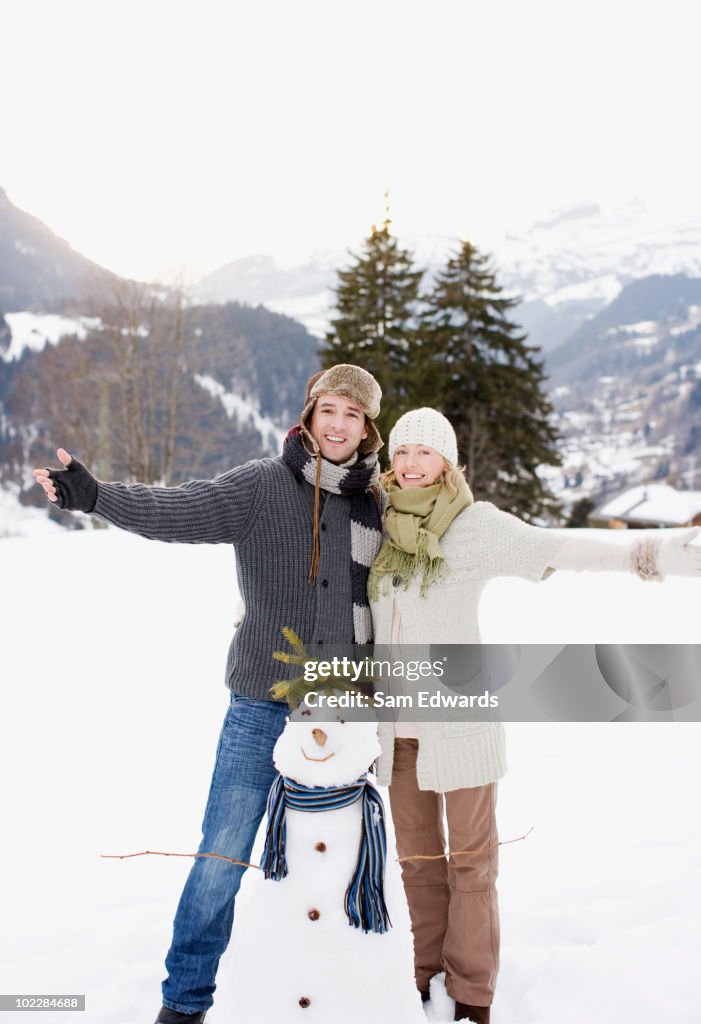 Couple standing with snowman
