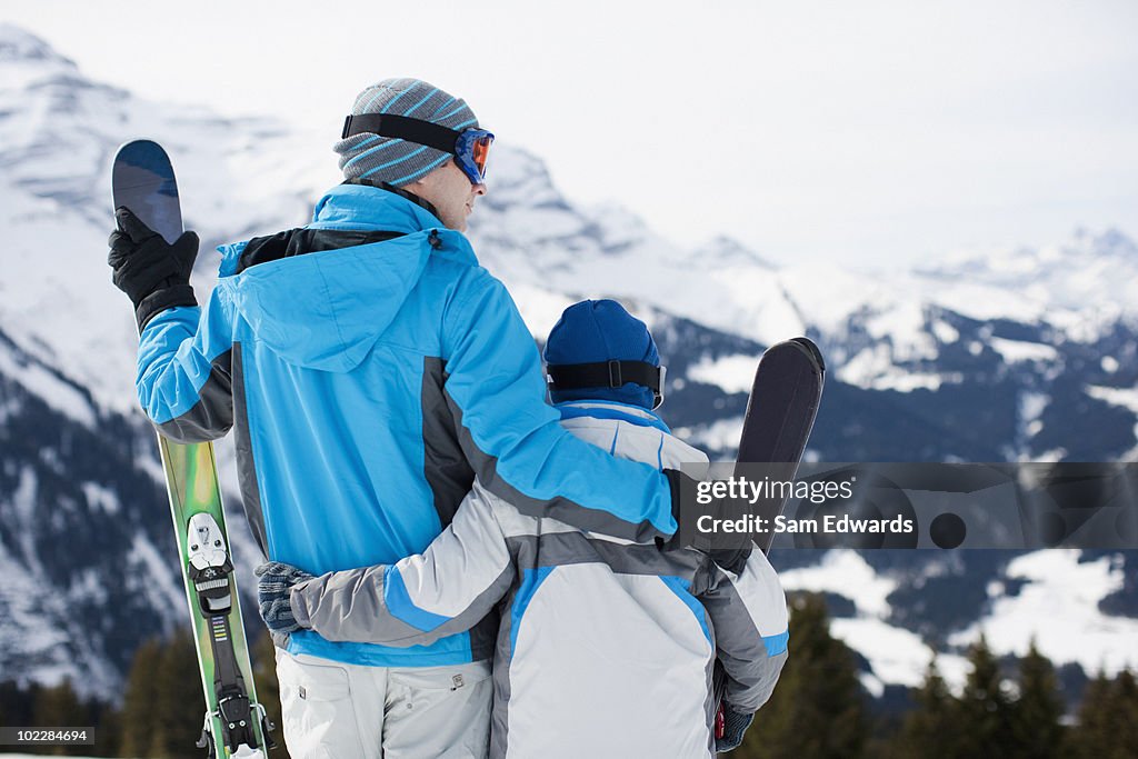 Father and son holding skis