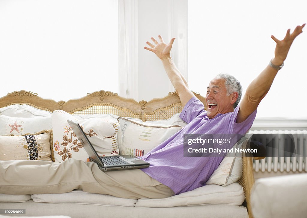 Cheering man using laptop