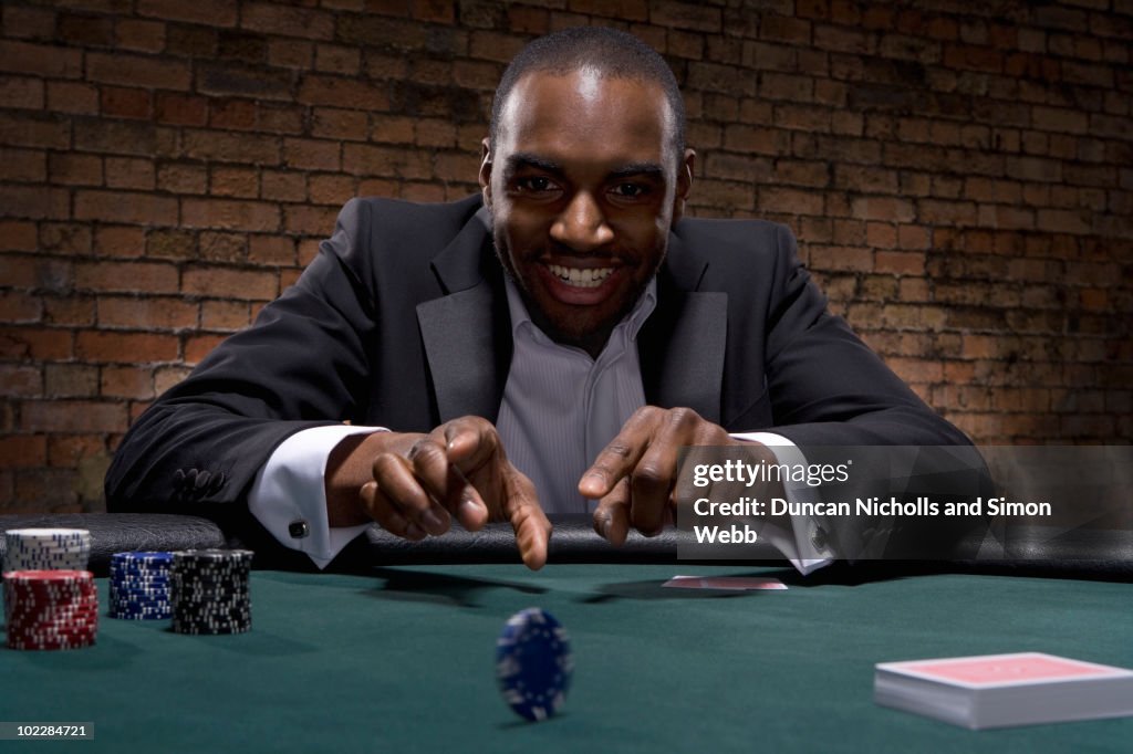 Man rolling poker chip in casino