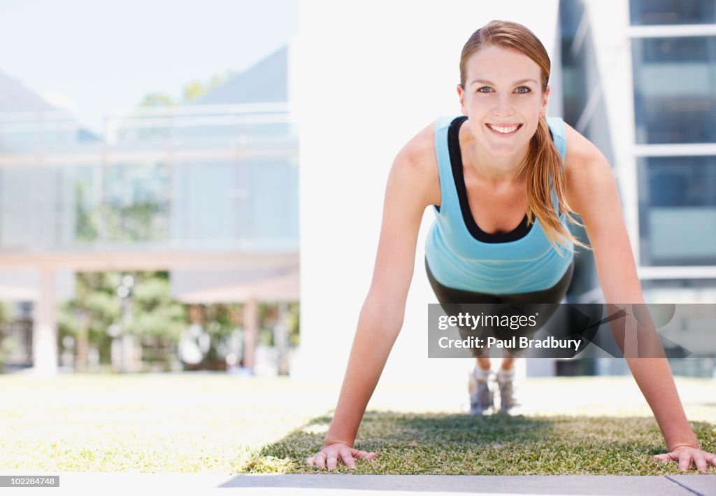 Woman doing push-ups in urban setting