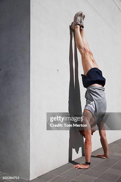 homme en équilibre sur les mains dans un cadre urbain - handstand photos et images de collection