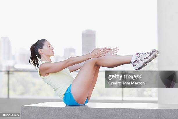 donna facendo sit ups in ambiente urbano - sit up foto e immagini stock