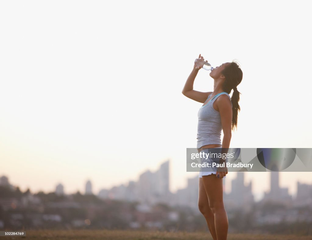 Woman drinking water after exercise