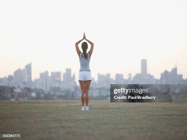 woman practicing yoga in urban park - harmony day stock pictures, royalty-free photos & images