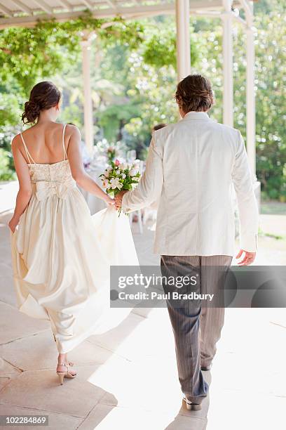 bride and groom holding hands - moving after stock pictures, royalty-free photos & images
