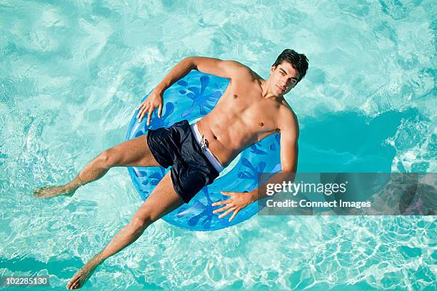 man on inflatable ring in pool - badkläder bildbanksfoton och bilder