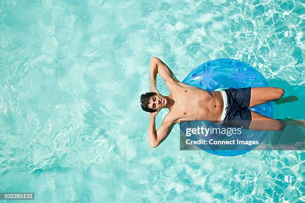 man on inflatable ring in pool - man pool stock pictures, royalty-free photos & images