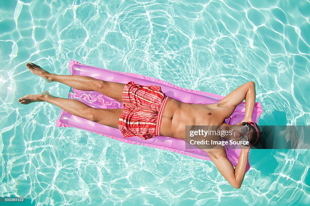 Man on inflatable mattress in pool