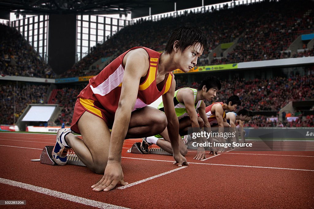 Runners at starting line in stadium