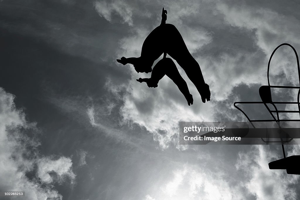 Silhouette of swimmers diving