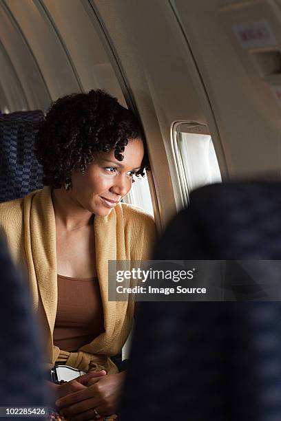 female airplane passenger looking out of window - airplane front view stock pictures, royalty-free photos & images