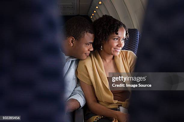 couple on an airplane - vliegtuigstoel stockfoto's en -beelden