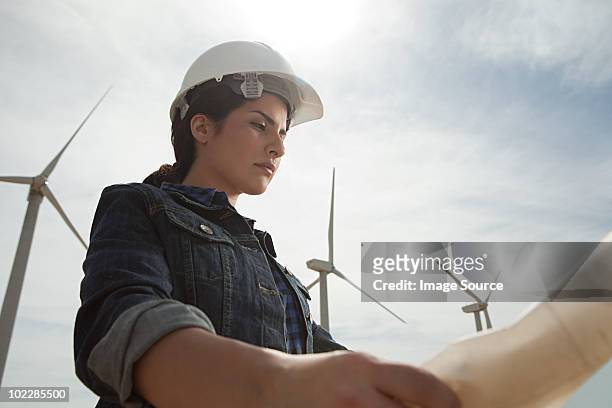 femmina engineer presso vento di fattoria con piani - engineering foto e immagini stock