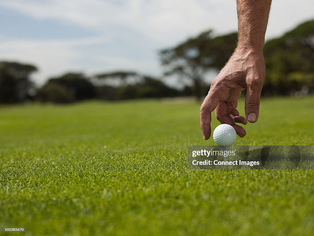 Man playing golf, picking up ball