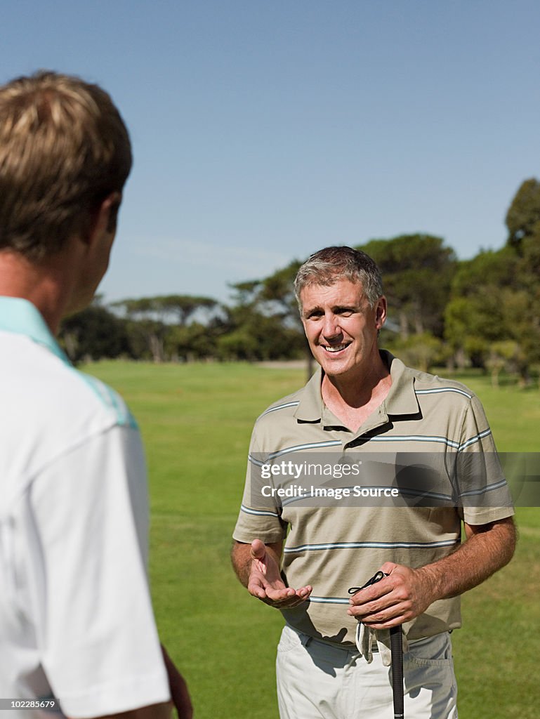 Two mature men playing golf together