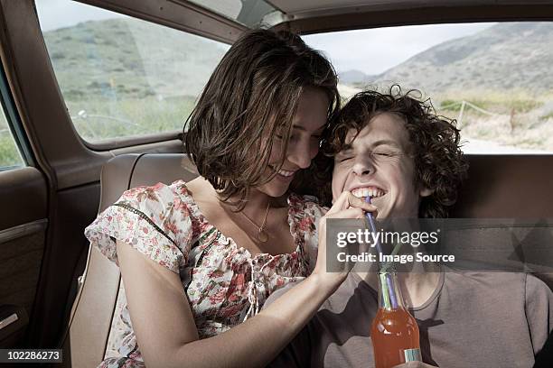 young couple drinking soda in car - drinking soda in car stock pictures, royalty-free photos & images