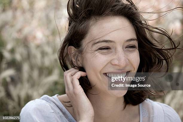 young brunette woman alone outdoors, portrait - brown hair blowing stock pictures, royalty-free photos & images