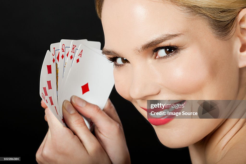 Young blonde woman playing cards