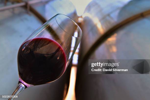 Worker takes samples of Cabernet Sauvignon wine from large stainless steel fermentation tanks at the height of the wine harvest at Carmel Winery,...