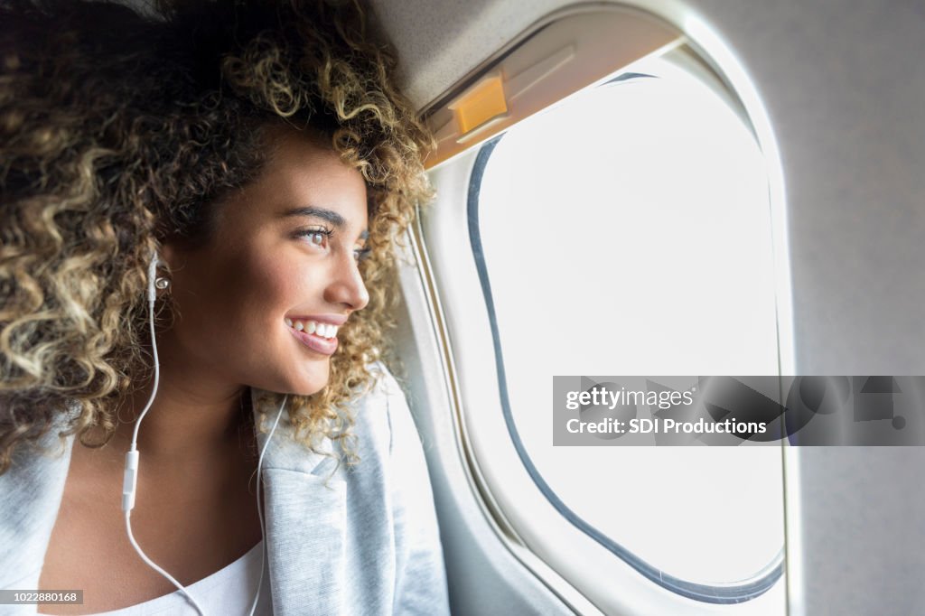 Kvinna som tittar genom fönstret på flygplan