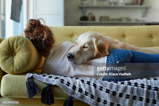 girl sleeping on couch with her golden retriever dog - day of rage grips jerusalem and west bank stockfoto's en -beelden
