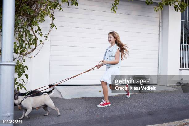 Cute girl walking with dogs on the street