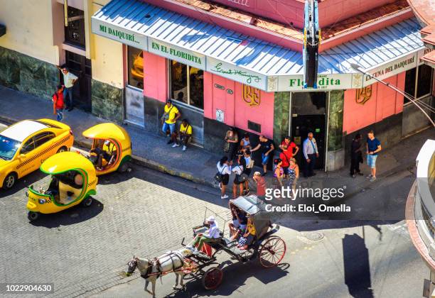 paard en wagen en coco taxi vooraan la floridita bar in havana. cuba - la habana stockfoto's en -beelden