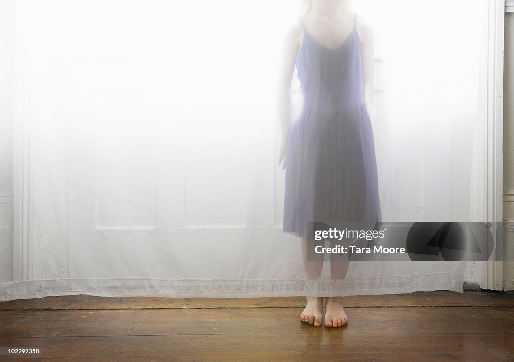 Girl standing behind curtain