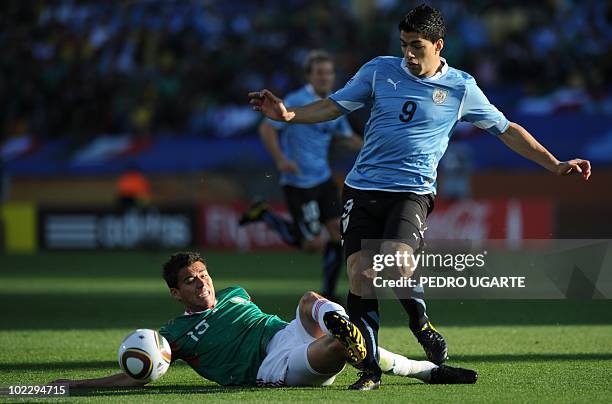 Mexico's defender Hector Moreno fights for the ball from the ground with Uruguay's striker Luis Suarez during their Group A first round 2010 World...