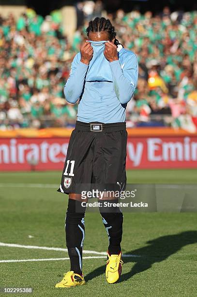 Alvaro Pereira of Uruguay covers his face with his shirt during the 2010 FIFA World Cup South Africa Group A match between Mexico and Uruguay at the...