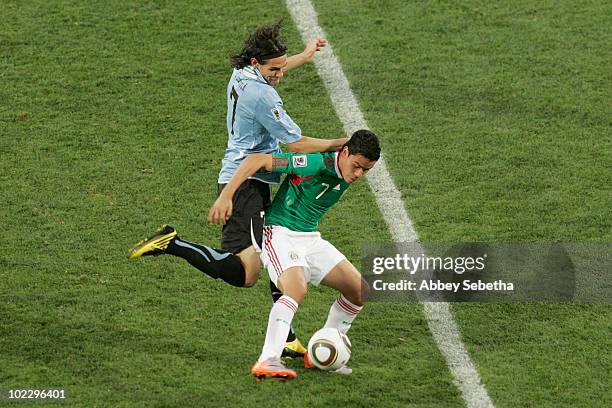 Edinson Cavani of Uruguay and Pablo Barrera of Mexico battle for the ball during the 2010 FIFA World Cup South Africa Group A match between Mexico...