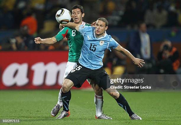 Israel Castro of Mexico and Diego Perez of Uruguay battle for the ball during the 2010 FIFA World Cup South Africa Group A match between Mexico and...