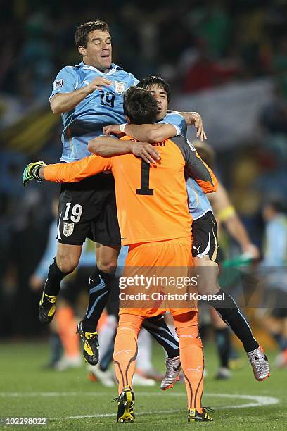 Fernando Muslera of Uruguay celebrates with team mates Andres Scotti and Jorge Fucile after victory in the 2010 FIFA World Cup South Africa Group A...