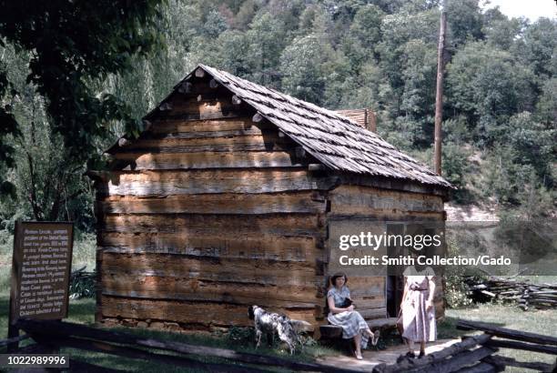 Female tourists gather outside a log cabin at the birthplace of United States President Abraham Lincoln, Kentucky, United States, 1955.