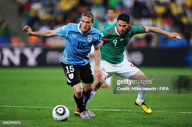 Diego Perez of Uruguay is challenged by Guillermo Franco of Mexico during the 2010 FIFA World Cup South Africa Group A match between Mexico and...