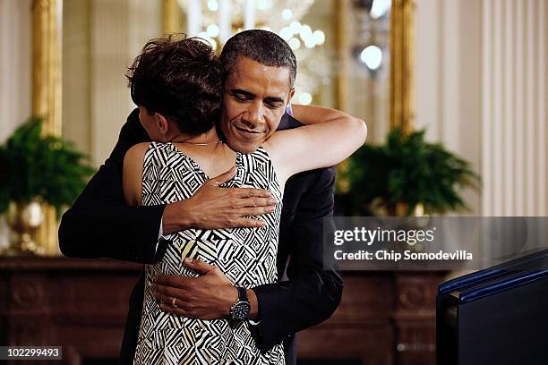 President Barack Obama embraces Amy Wilhite of Marblehead, Ohio, before speaking during an event to mark the 90-day anniversary of the signing of the...