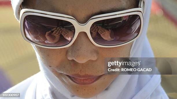 Female member of the Indonesian Islamists organization prays during a rally in central Jakarta on June 22, 2010 to demand the stoning to death and...